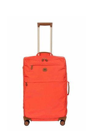 Grande valise souple orange avec poignée rétractable marron, poche avant zippée, poignée latérale et quatre roulettes pivotantes.