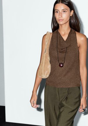 Brown knitted sleeveless top with a cowl neckline, paired with olive green wide-leg trousers and a beige suede shoulder bag.