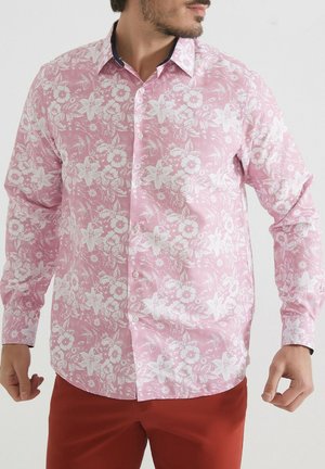 Chemise rose à boutons avec un motif floral blanc, manches longues et un col bleu marine en accent. Tissu lisse avec une coupe régulière.
