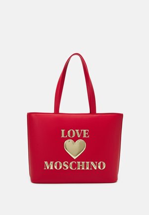 Czerwona torba typu tote z dwoma uchwytami i złotym napisem "LOVE" nad kształtem serca oraz "MOSCHINO" poniżej na przedniej stronie.