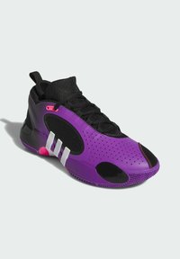 Chaussure de sport violette avec des accents noirs, tige texturée, perforations, et trois bandes blanches. Présente une pointe arrondie et une semelle en caoutchouc.