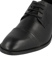 Scarpe eleganti in pelle nera con finitura liscia, punta affusolata, design con lacci e cuciture tonali sulla punta e sulla tomaia.