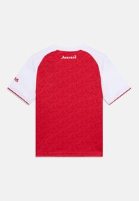 Rød og hvit kortermet trøye med en strukturert rød rygg som har et subtilt mønster. "Arsenal"-logo over nakken på et solid hvitt panel.