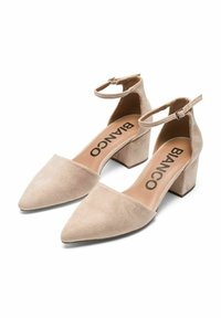 Zapatos de tacón cuadrado de ante beige con punta afilada y correa en el tobillo. Presentan una plantilla en tono marrón con el logotipo 'BIANCO' en negro.