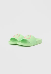 Green slide sandals made of rubber with open toe. Features two smiling face designs in pink on the straps. Flat sole, casual style.