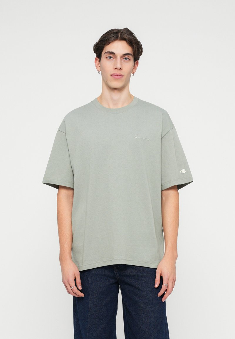Tricou din bumbac de culoare verde deschis, cu mâneci scurte, decolteu rotund și broderie subtilă a logo-ului pe piept. Purtați-l cu blugi de culoare albastru închis.