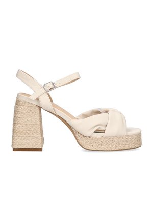 Sandal de tacón alto beige con un detalle anudado, correa de tobillo ajustable y tacón de yute trenzado. Parte superior de sintético suave y suela texturizada.