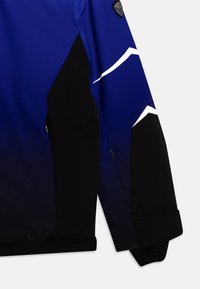 Blue and black jacket featuring a color gradient, textured fabric, and a white angular design on the sleeve, with zippered pocket.