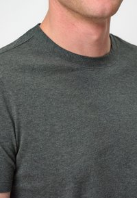 Mörkgrå t-shirt med kort ärm, rund halsringning, tillverkad av en bomullsmix, har en subtil textur och minimala sömnadsdetaljer.