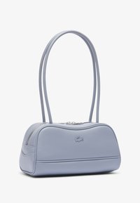 Borsa a mano in pelle azzurra chiara con lunghe tracolle doppie, chiusura a zip e piccolo logo in rilievo di coccodrillo sul davanti.