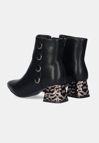 Botas de tobillo negras hechas de cuero suave, con punta afilada, cremallera lateral y tacones de print de leopardo metálico texturizado en rosa y negro.