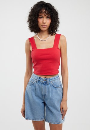 Punane ribaga lühike topp ruudukujulise kaelusega ja la rộngi õlapaeladega, koos kõrge vöökohaga helesiniste denim lühikeste pükstega, millel on eestaskud.