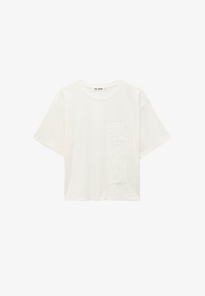 Weißes T-Shirt mit kurzen Ärmeln, Rundhalsausschnitt und dekorativer gehäkelter Tasche mit Fransen auf der Vorderseite rechts.