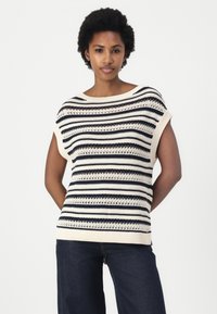 Strikkegenser med kremfargede og marineblå horisontale striper, åpen heklet tekstur, bred utringing og korte dolman-ermer.
