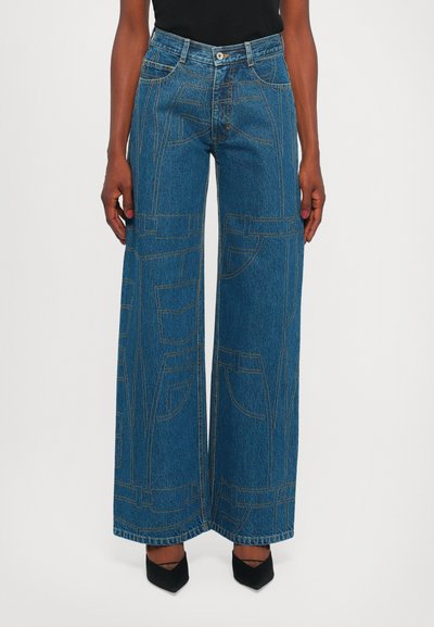 Pantalon en denim à jambe large de couleur bleu moyen avec des coutures contrastées, quatre poches et une fermeture à bouton. Texture lisse et design décontracté.