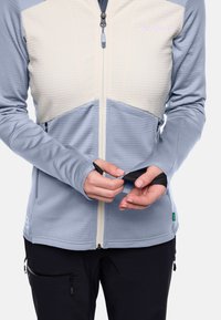Lichtblauwe en crème twee-kleurige ritsjack met gewatteerd bovenpaneel, duimgaten en ritszakken. Glad textuur en slim fit ontwerp.