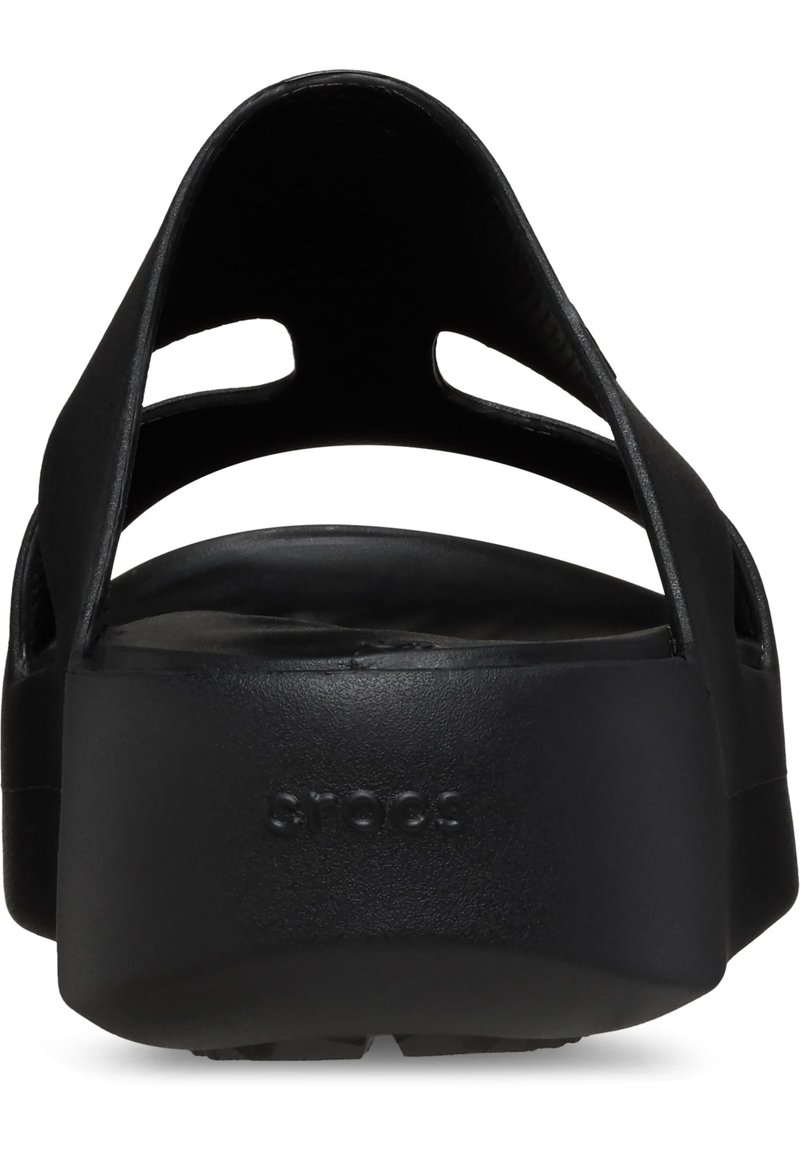 Sandales à plateforme noires avec une texture lisse et mate, comportant des détails découpés sur les brides supérieures et un coussin de pied profilé.