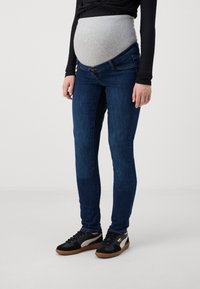 Jeans de maternidad en denim azul oscuro con un panel de jersey gris flexible, corte ajustado, a media altura, con cierre de botón y costuras sutiles.