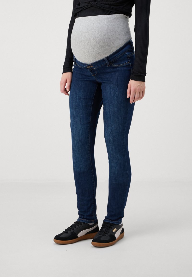 Jeans de maternidad en denim azul oscuro con un panel de jersey gris flexible, corte ajustado, a media altura, con cierre de botón y costuras sutiles.
