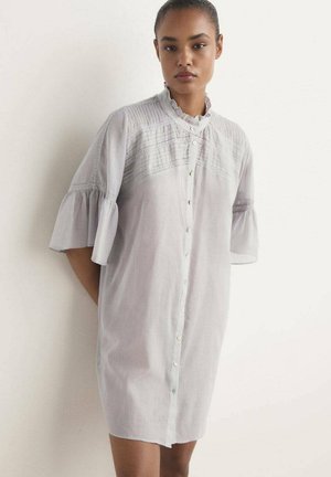 Vestido de camisa gris claro con cuello con volantes y mangas cortas acampanadas. Presenta una textura sutil y una parte delantera abotonada con un corte holgado.