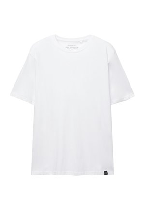 Witte katoenen T-shirt met een normale pasvorm, ronde hals, korte mouwen en een klein merketiket aan de onderkant aan de linkerkant. Zachte textuur.