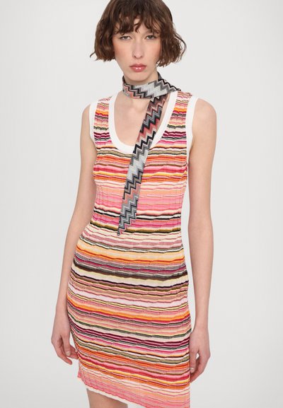 Megztinis su dryžuota raštą rožinės, oranžinės ir juodos spalvų. Baltas apykaklės apvadas. Papildytas zigzago raštuota šaliku.