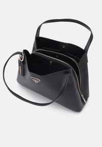 Borsa sintetica nera con design strutturato, doppie tasche con zip, manico corto e dettagli in metallo dorato.