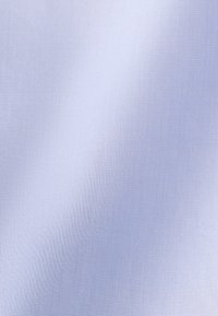 Vue rapprochée d'un tissu bleu clair lisse avec une texture tissée fine et des ombres subtiles.