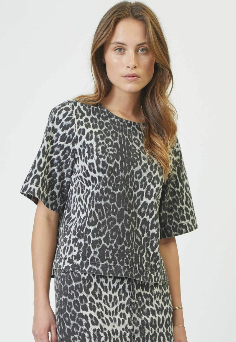 Top a maniche corte con stampa leopardata nei toni del nero e del grigio, caratterizzato da una vestibilità relaxed e un colletto rotondo con una texture liscia.