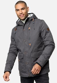 Grijze, capuchonjack met bruine leren accenten, grote voorkennis en een ritszak. Voorzien van toggles en een gestructureerde binnenvoering.