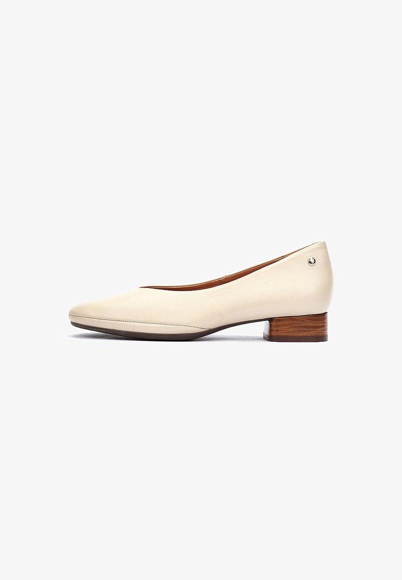 Ballerines en cuir beige avec un bout rond, un petit talon en bois et des détails de couture minimalistes. Texture lisse, silhouette classique.