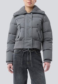 Jachetă puff gri scurtă cu guler din tricot cu nervuri, nasturi tip snap și buzunare laterale; asortată cu blugi din denim închis cu talie înaltă.