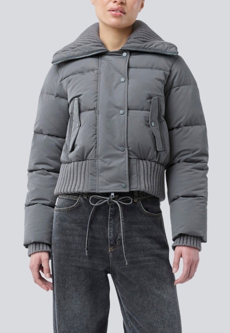 Jachetă puff gri scurtă cu guler din tricot cu nervuri, nasturi tip snap și buzunare laterale; asortată cu blugi din denim închis cu talie înaltă.
