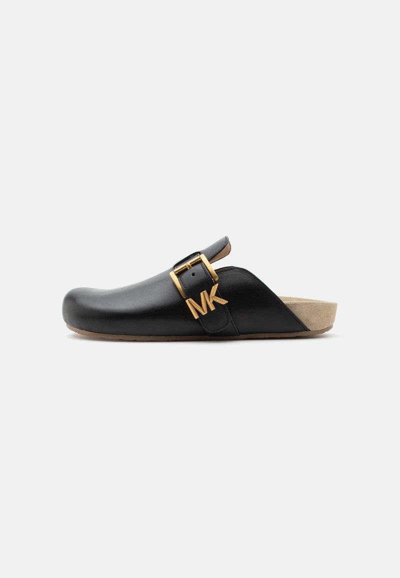 Sabot en cuir noir à enfiler avec semelle beige et bride à boucle dorée avec logo MK sur fond clair uni.