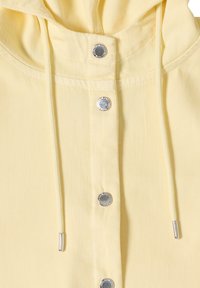 Sweat à capuche en tissu jaune devant avec boutons-pression argentés et cordons assortis avec embouts métalliques argentés.