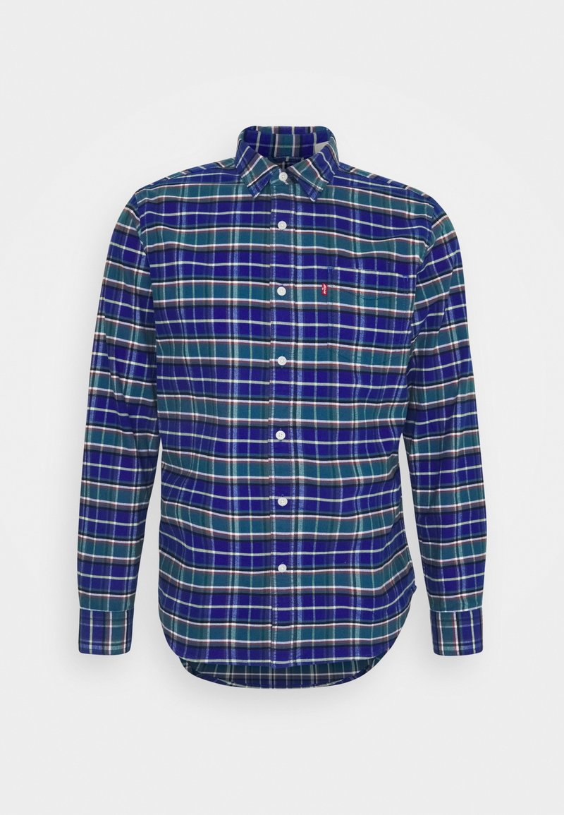 Chemise à manches longues boutonnée avec motif à carreaux verts, bleus et blancs et une poche avant sur fond blanc uni.