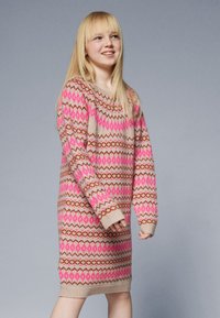 Knit sweater dress in beige with pink and brown geometric patterns, long sleeves, and ribbed cuffs, designed for a relaxed fit.