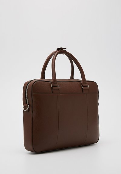 Trousse en cuir marron avec deux poignées supérieures, une fermeture éclair, et un grain texturé subtil. Présente une forme rectangulaire élégante et des accents latéraux.