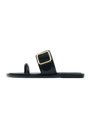 Black flat sandal with a wide strap featuring a gold square buckle. The material appears smooth, with a minimalist design and open-toe shape.