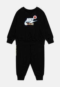 Tuta Nike nera con maniche lunghe e pantaloni. La grafica frontale presenta "NIKE" e "JUST DO IT" con accenti in blu, verde e rosso.
