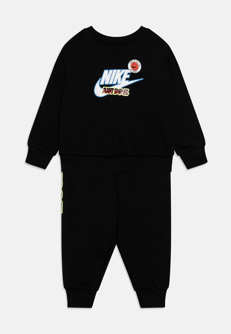 Tuta Nike nera con maniche lunghe e pantaloni. La grafica frontale presenta "NIKE" e "JUST DO IT" con accenti in blu, verde e rosso.