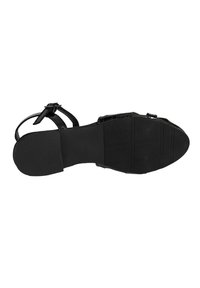 Schwarze offene Sandale mit verstellbarem Knöchelriemen, Gummisohle und strukturiertem Obermaterial. Das Design ist minimalistisch und verfügt über einen flachen Absatz.