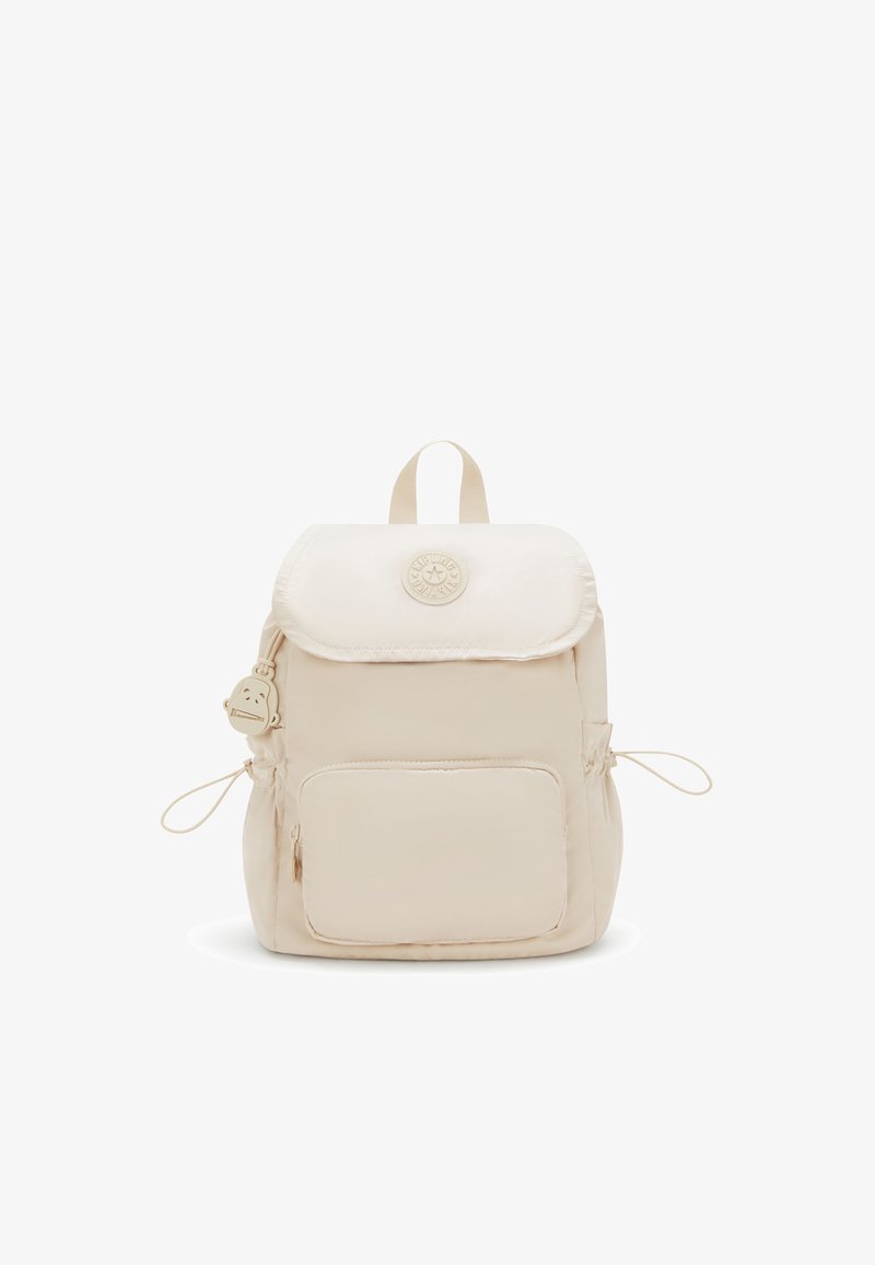Beige Nylon-Rucksack mit Reißverschlussfach vorne, Klappenverschluss, seitlichen Kordeln, Traggriff oben und rundem Logo-Patch mit Affen-Schlüsselanhänger.