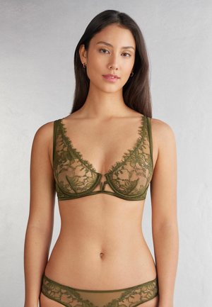 Olijfgroene kant bralette met doorschijnende bloemenpatronen. Bevat een V-hals en smalle bandjes, gecombineerd met bijpassende kanten string.