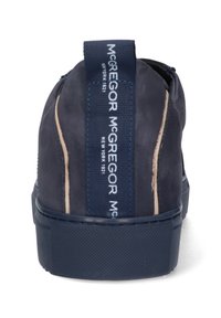 Mörkblå sneakers med en texturerad mockaöverdel, vit kontrastsömnad och en märkeslogotyp i tyg som dragsko på hälen. Cirkulär gummisula.