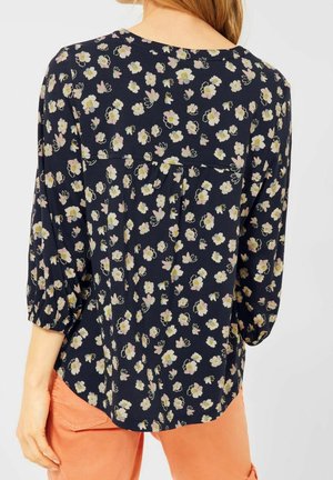 Granatowa bluzka w różowo-żółty kwiatowy wzór. Posiada rękawy do łokcia, okrągły dekolt oraz lekko zakrzywiony dół.