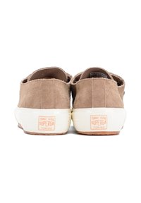 Sneakers in suede marrone con suole in gomma bianca. Le caratteristiche includono un design a taglio basso e un tallone testurizzato con il logo del marchio sul retro.