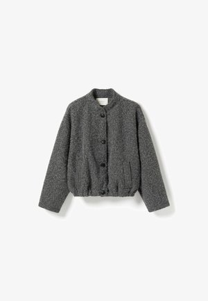 Grå tekstureret jakke, rund halsudskæring, fem sorte knapper, elastisk kant og sidelomme. Fremstillet af blødt stof med en lidt løs pasform.