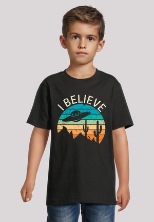 Black cotton t-shirt featuring a graphic design with a stylized UFO, desert mountains, and cacti against a multi-colored sunset background.