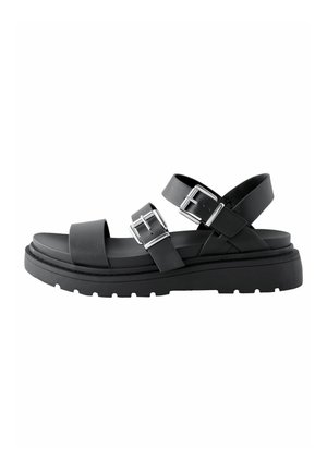 Sort sandal lavet af tekstureret læder med to justerbare stropper og sølv spænder. Har en tyk gummisål med et sålmønster.